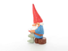 UpperDutch:,1 (ONE) Gnome, miniature Gnome after a design by Rien Poortvliet, Brb. David the Gnome, reading gnome sitting on a tree trunk.